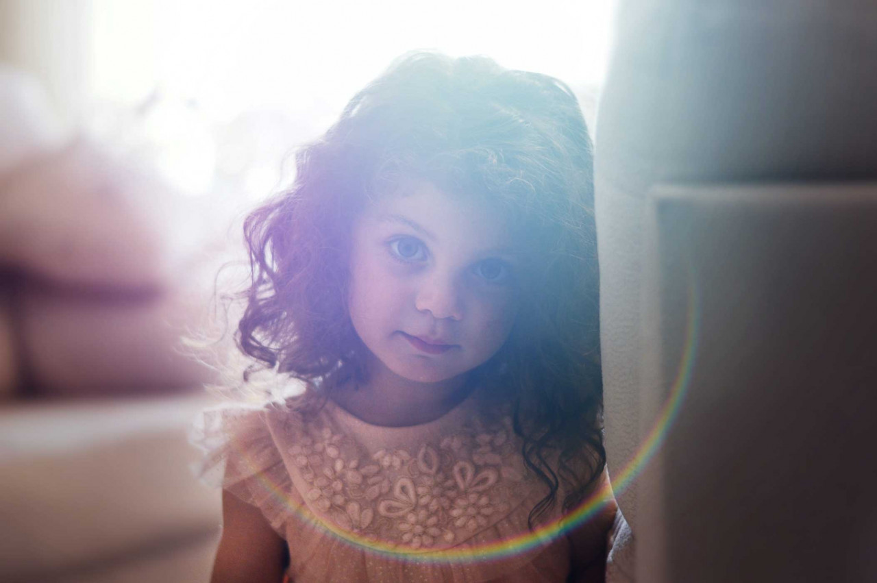 a young child with a bright sunlight behind her