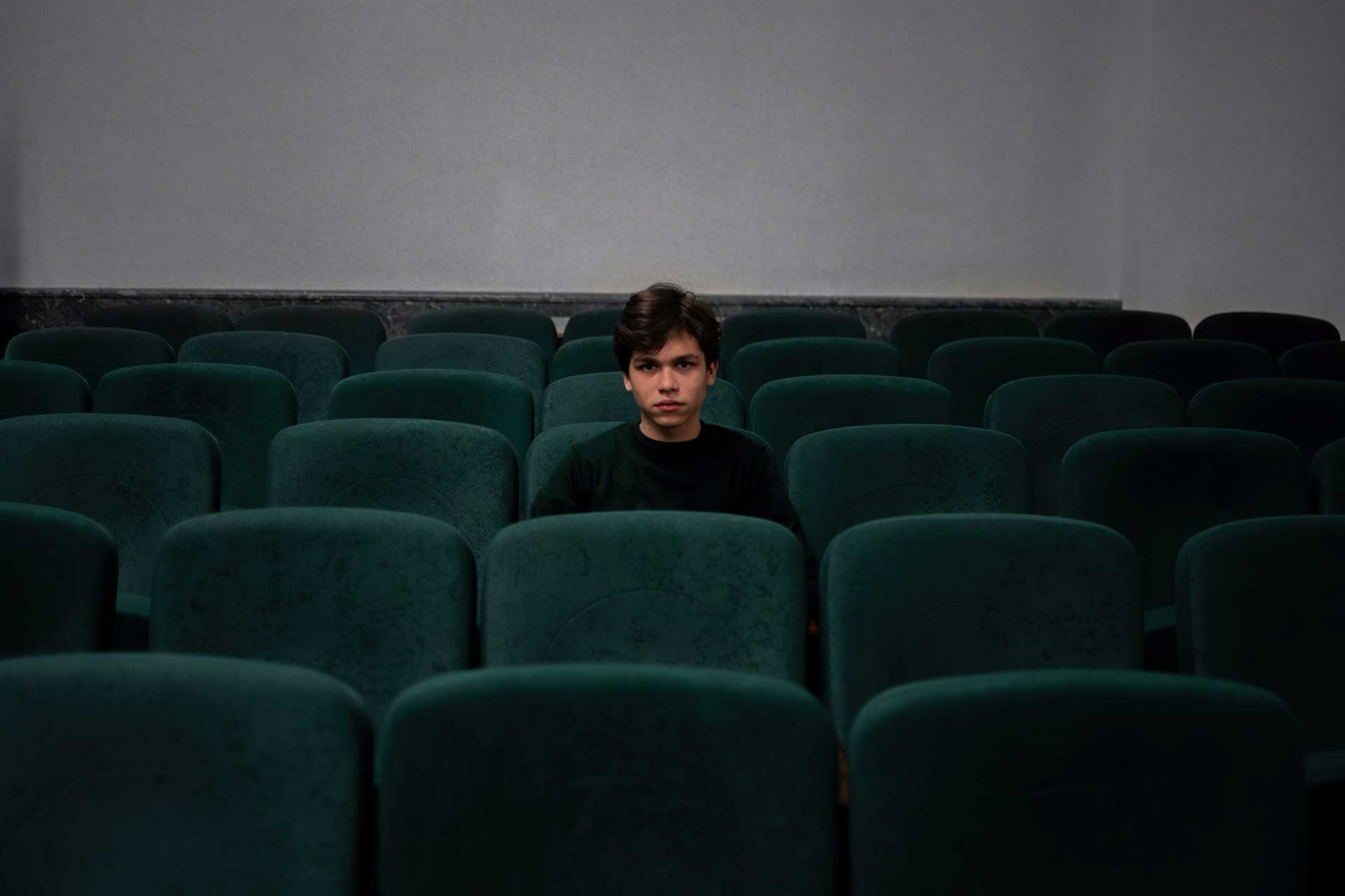 a young teenager sitting in a cinema