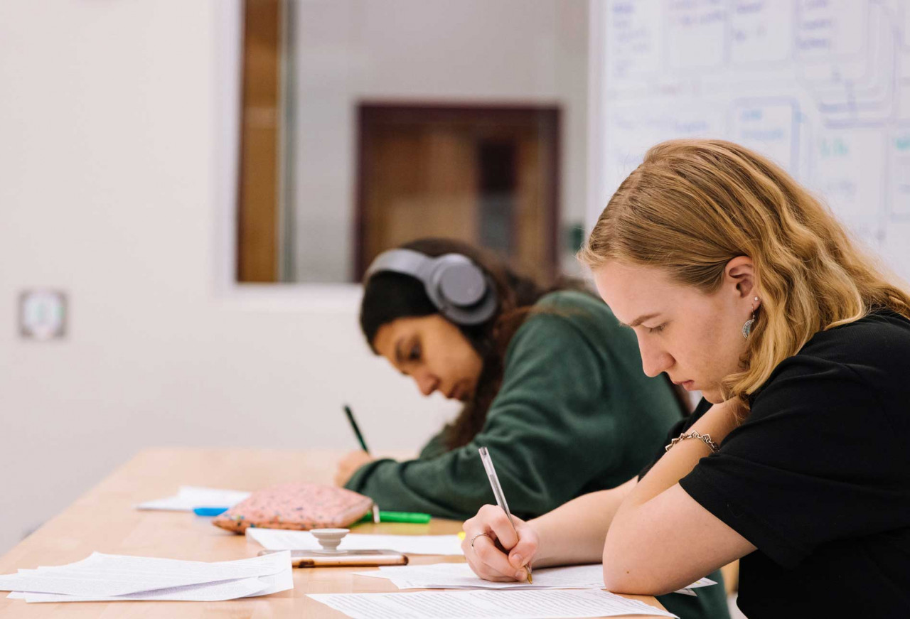 two teenagers sitting together working on an assignment