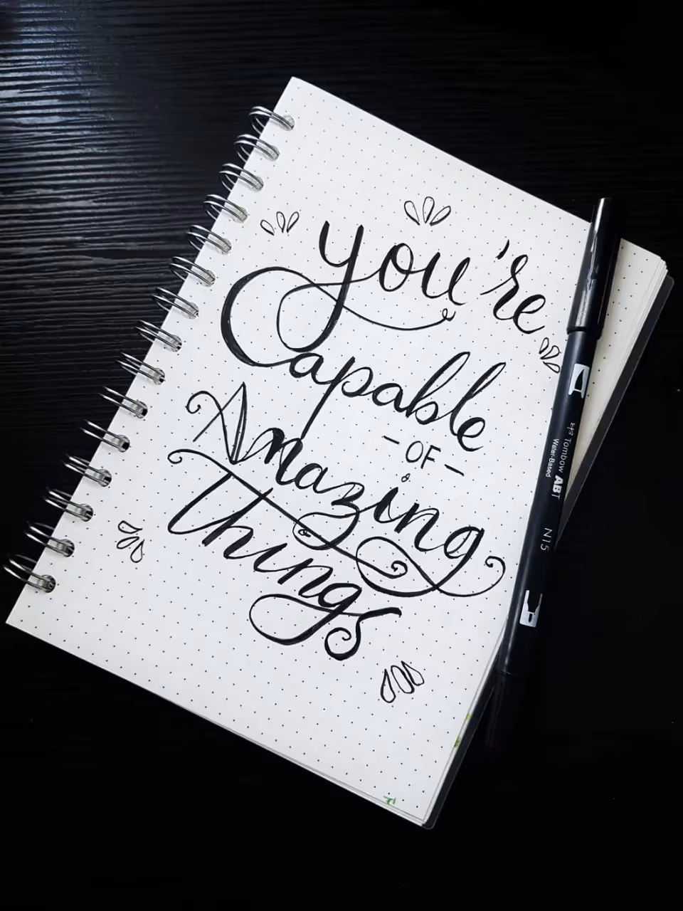 a notebook with the words you are capable of amazing things written on it