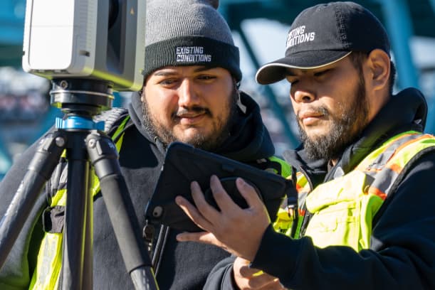 Project Managers reviewing existing conditions on an iPad at the job site.