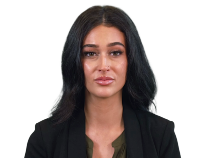 Portrait of a woman with long black hair wearing a black blazer and olive green top.