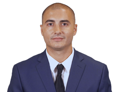 Portrait of a man wearing a navy blue suit, white shirt, and black tie against a transparent background.