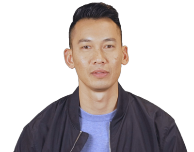 Young man with short dark hair wearing a black jacket and blue shirt on a white background.