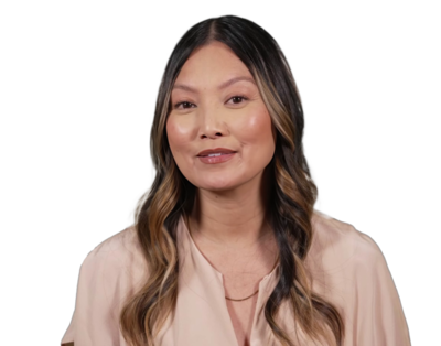 Portrait of a woman with long wavy hair wearing a light pink blouse, smiling slightly against a transparent background.
