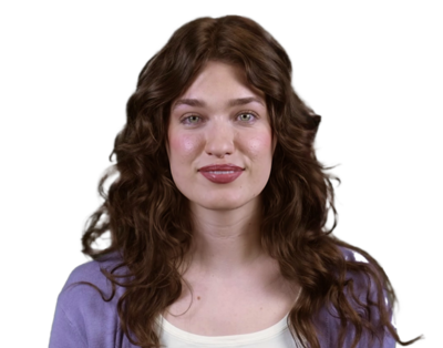 Young woman with long curly brown hair wearing a purple top and white shirt, looking at the camera with a neutral expression.