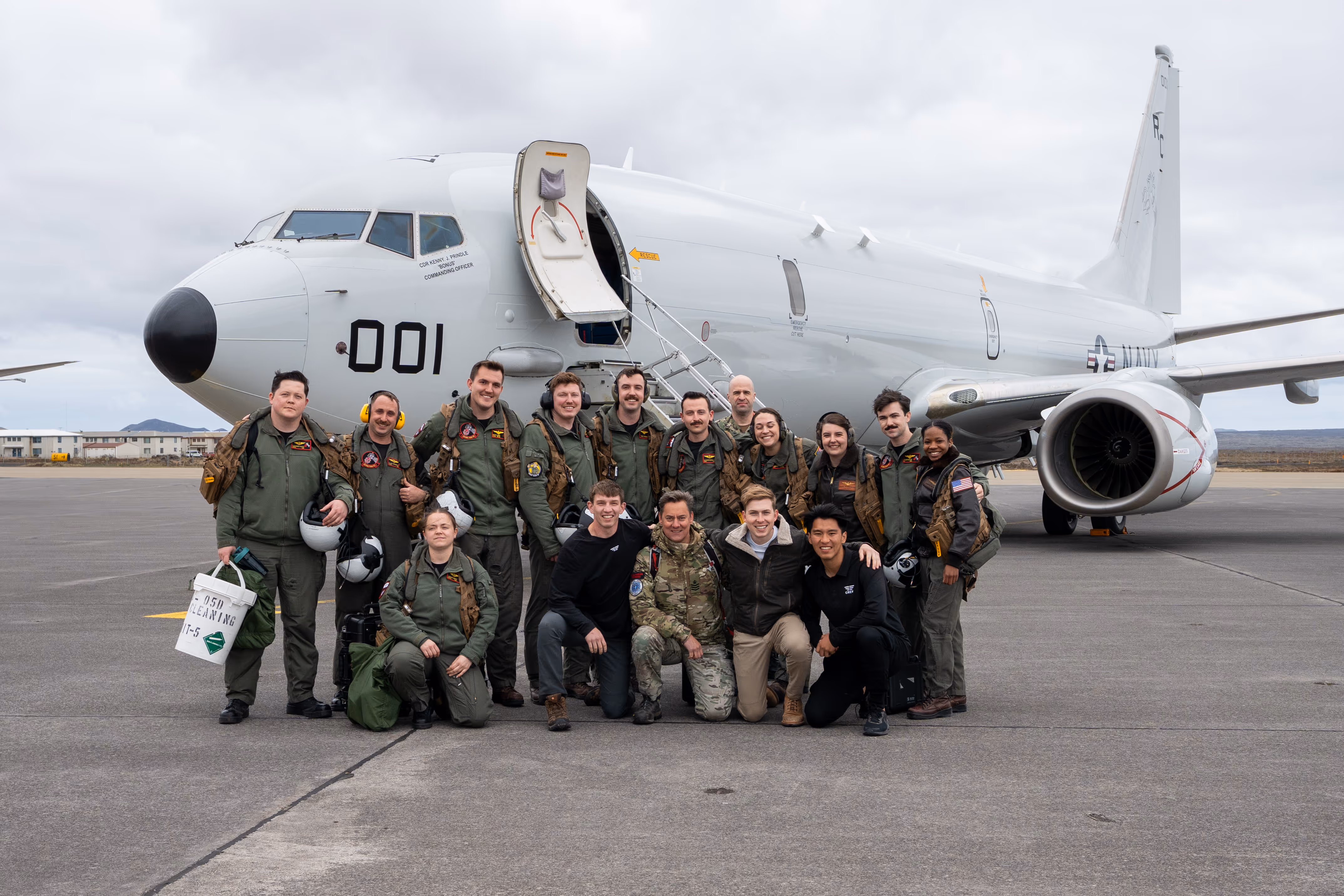 A picture of Sam Eckholm standing in front of a plane with a group of people