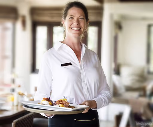 A woman in a white shirt holding a plate of food.