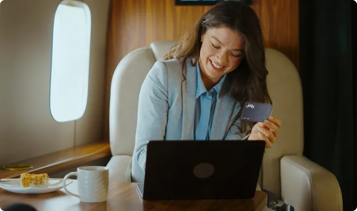 Black private jet aircraft on a flat surface with a cloudy sky background.