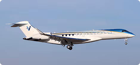 White ultra long-range private jet in flight against a clear blue sky.