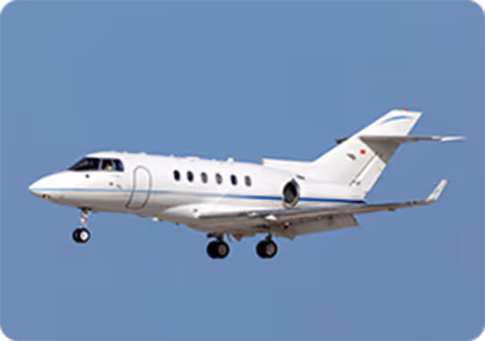 A small white plane flying through a blue sky.