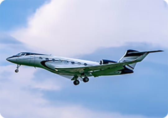A small plane flying through a cloudy blue sky.