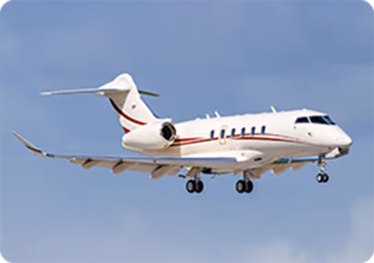 A small white airplane flying through a blue sky.