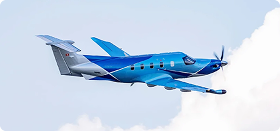 Blue single-engine turboprop airplane flying against a partly cloudy sky.