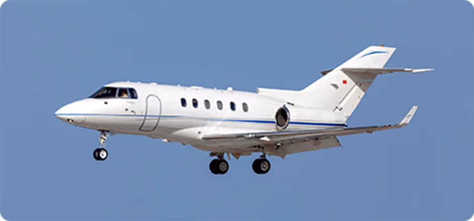 White private jet plane flying in clear blue sky with landing gear down.