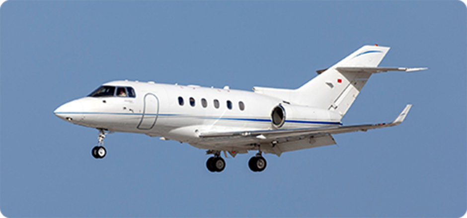 White private jet plane flying in clear blue sky with landing gear down.