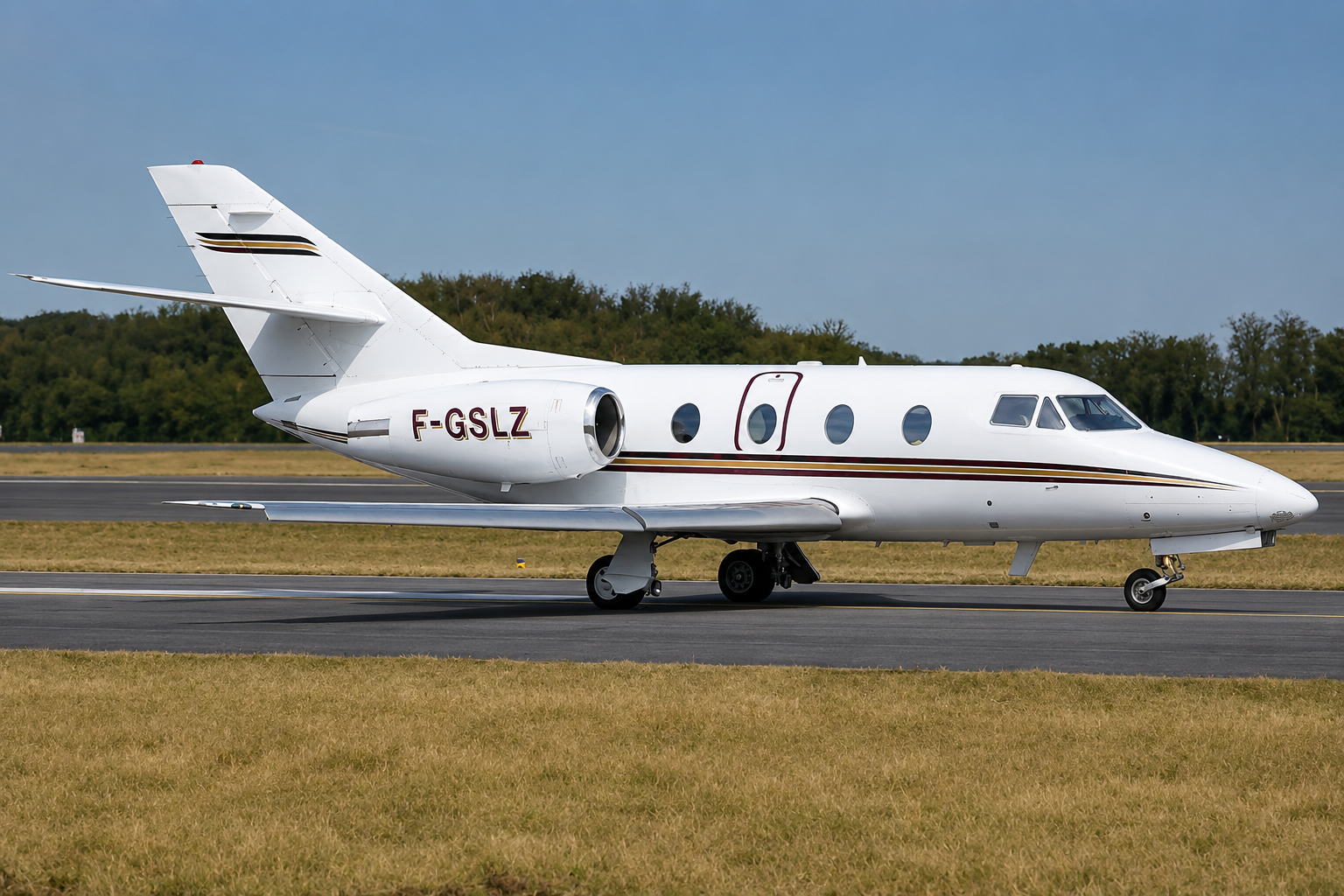 Small private jet with landing gear extended flying against a clear blue sky.