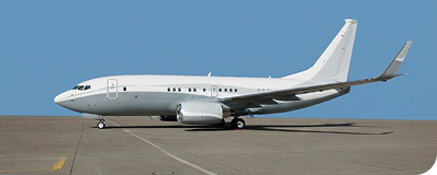 White private jet parked on runway under clear blue sky.
