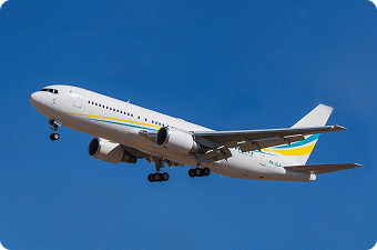White commercial airplane with blue and yellow stripes flying in clear blue sky.