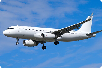 White commercial airplane flying with landing gear extended under a blue sky with clouds.