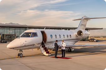 Private jet parked on runway with open door, two men on red carpet near stairs at sunset.