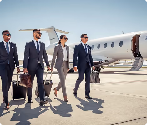 Four business professionals in suits walking with luggage near a private jet on an airport tarmac.