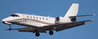 White private jet in flight against a clear blue sky.