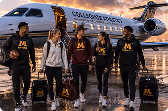 Five collegiate athletes standing with gear bags in front of a charter jet at sunset.