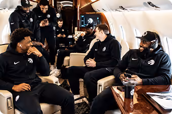 Toronto Raptors players laughing and chatting inside a private airplane cabin.