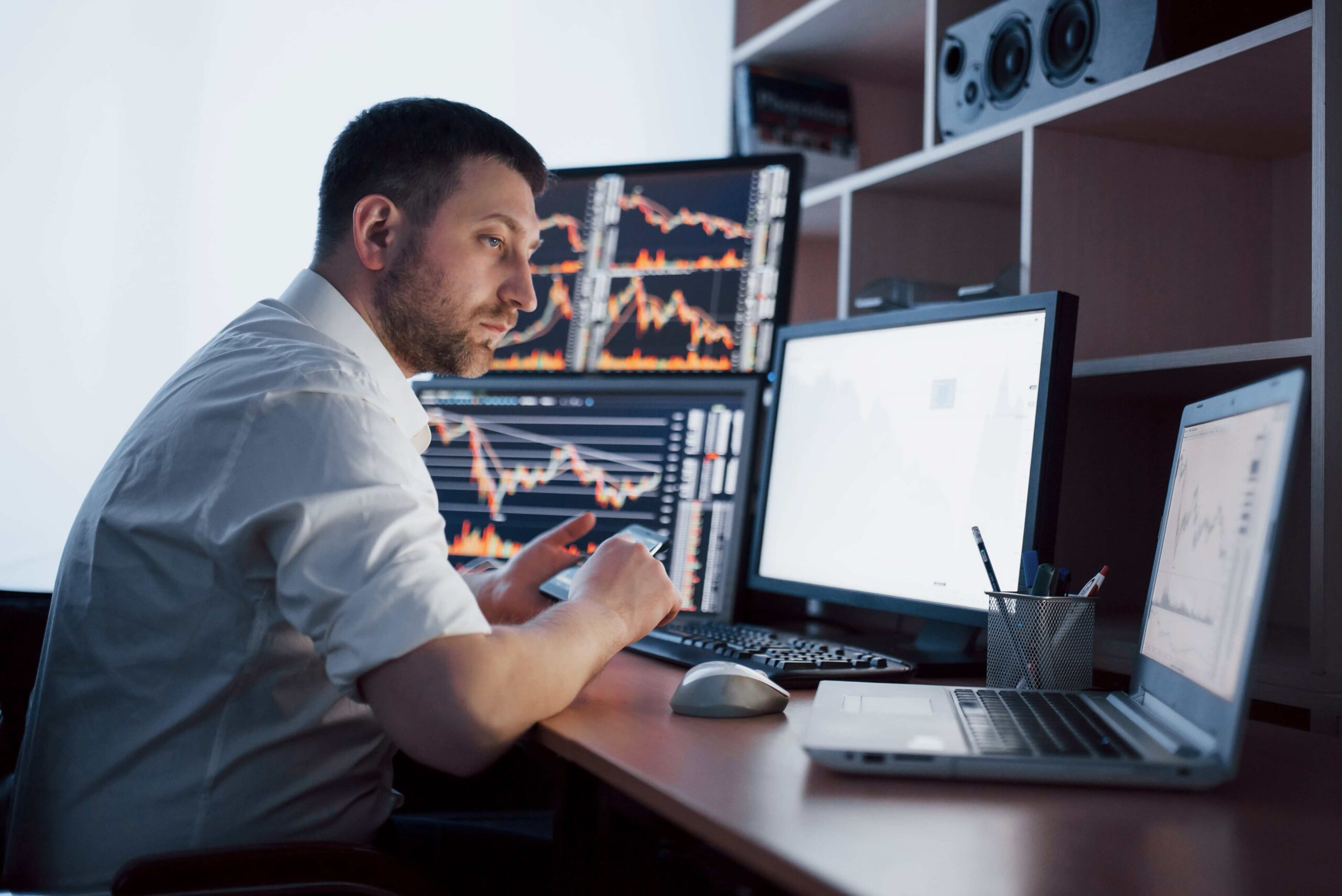 man trading on multiple screens - Automated Futures Trading