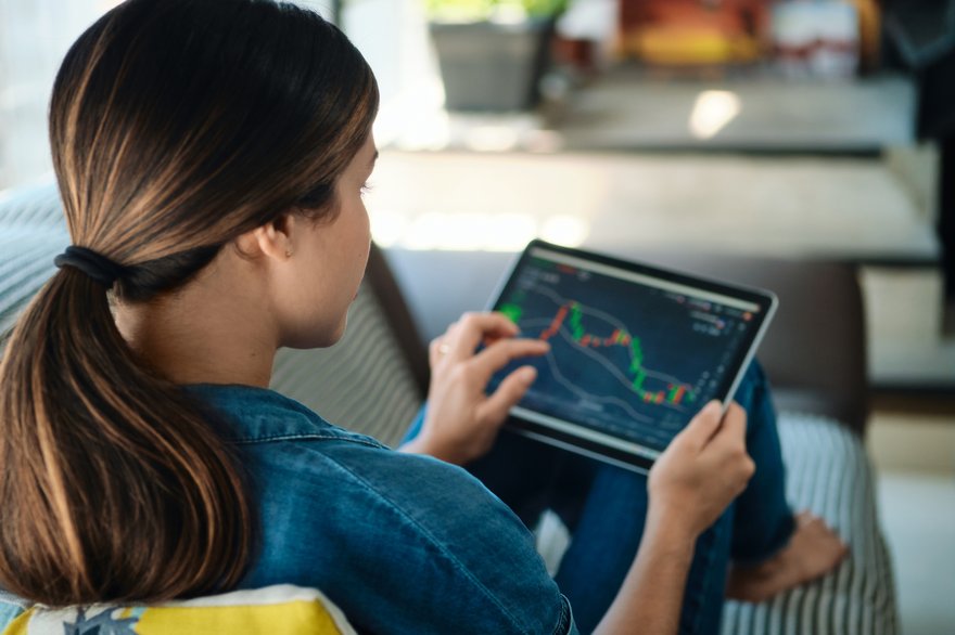 woman trading on a tablet - Automated Futures Trading Strategies