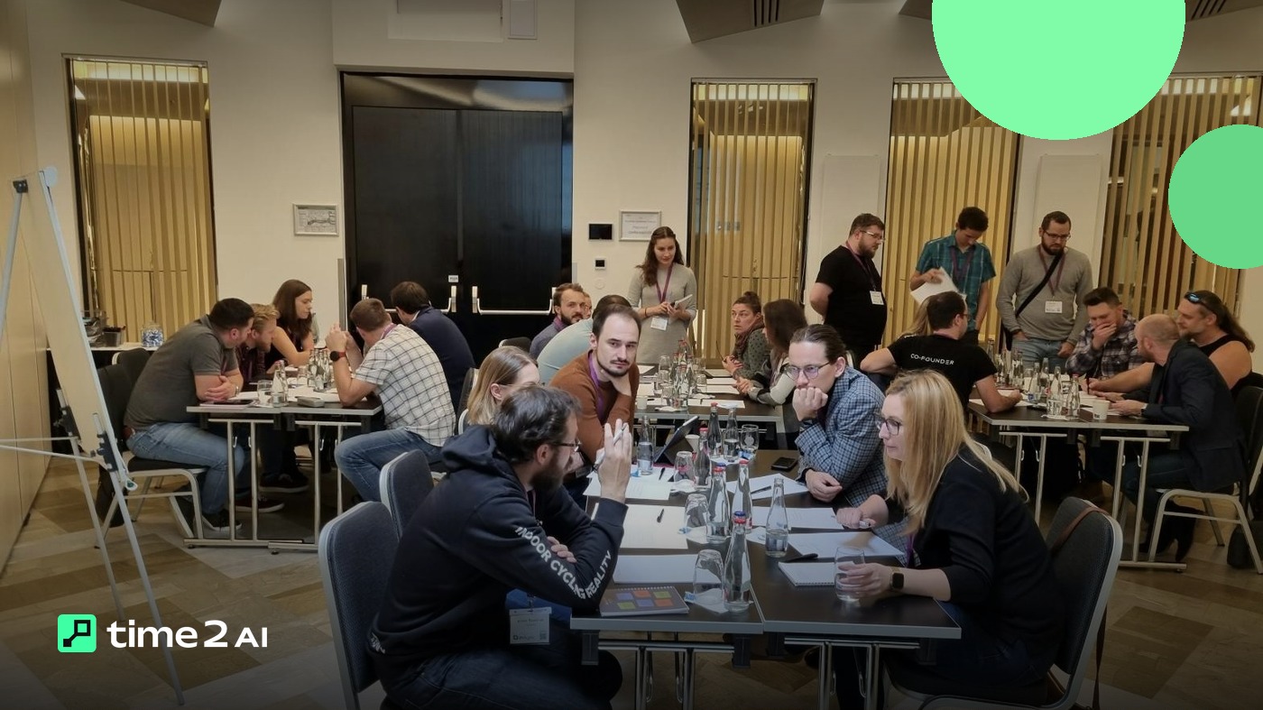 Salle de formation organisée en tables de travail, une animatrice debout au centre et un paperboard à gauche