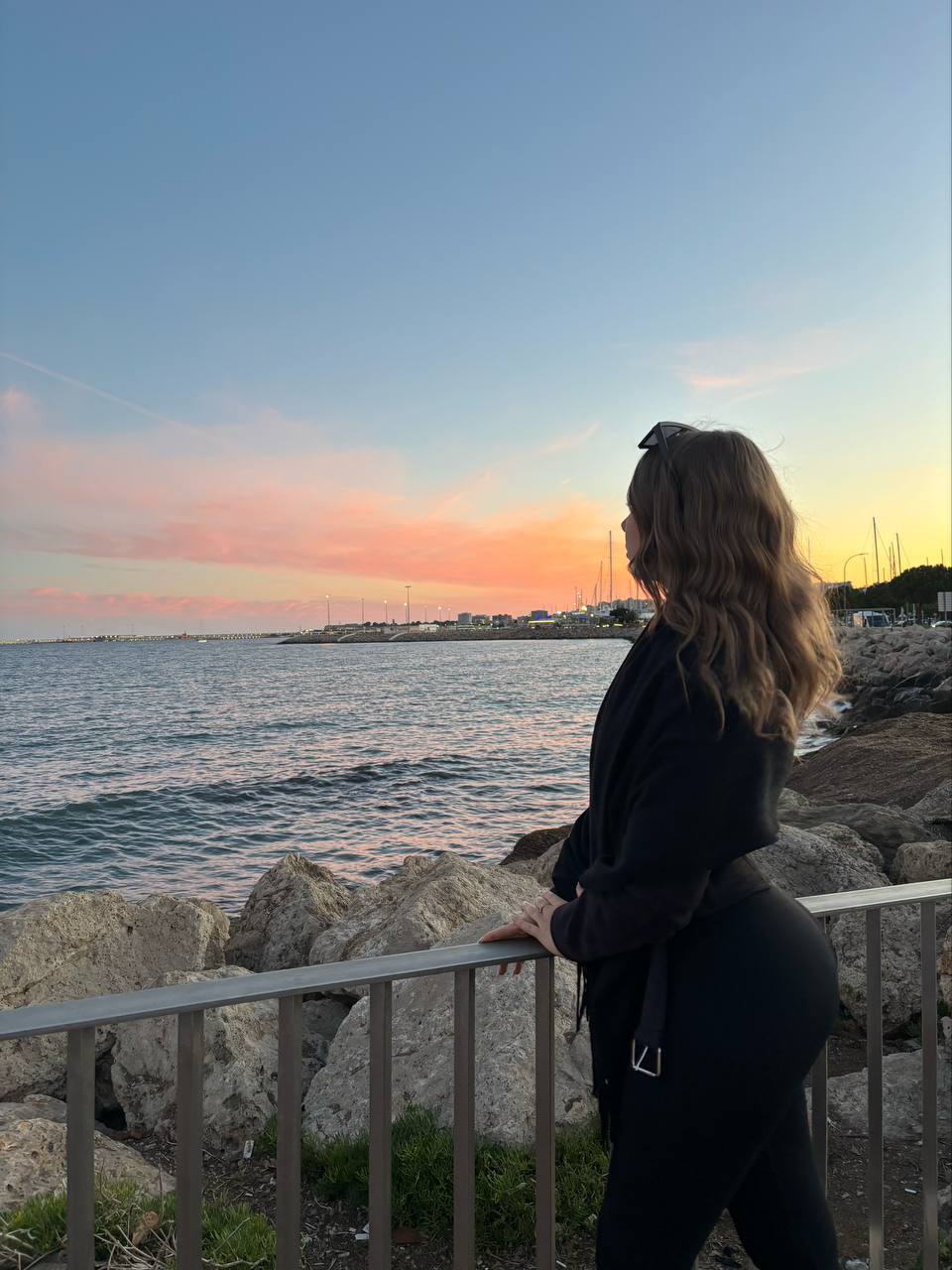 Eine Frau blickt auf das Meer bei Sonnenuntergang ruhige Atmosphäre passend für Creator-Auftritte