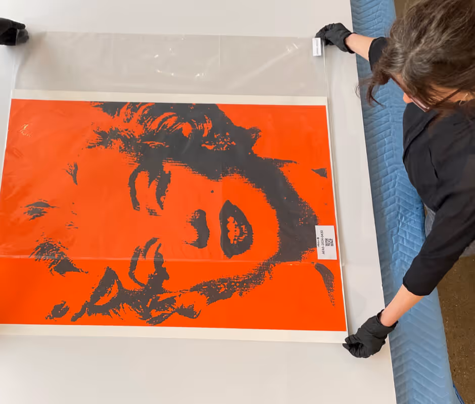 Atelier Fine Art Services, Art Handling professional using archival gloves to pack a print for collections management.