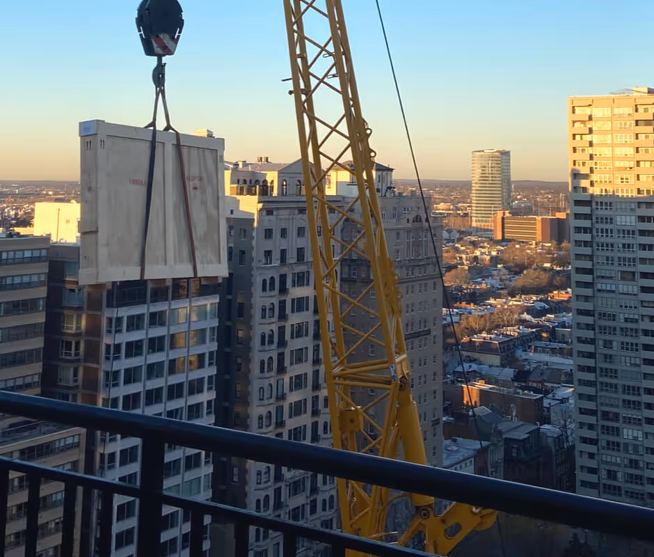 Atelier Fine Art Services coordinating a crane lift for a large art crate in a city center environment.