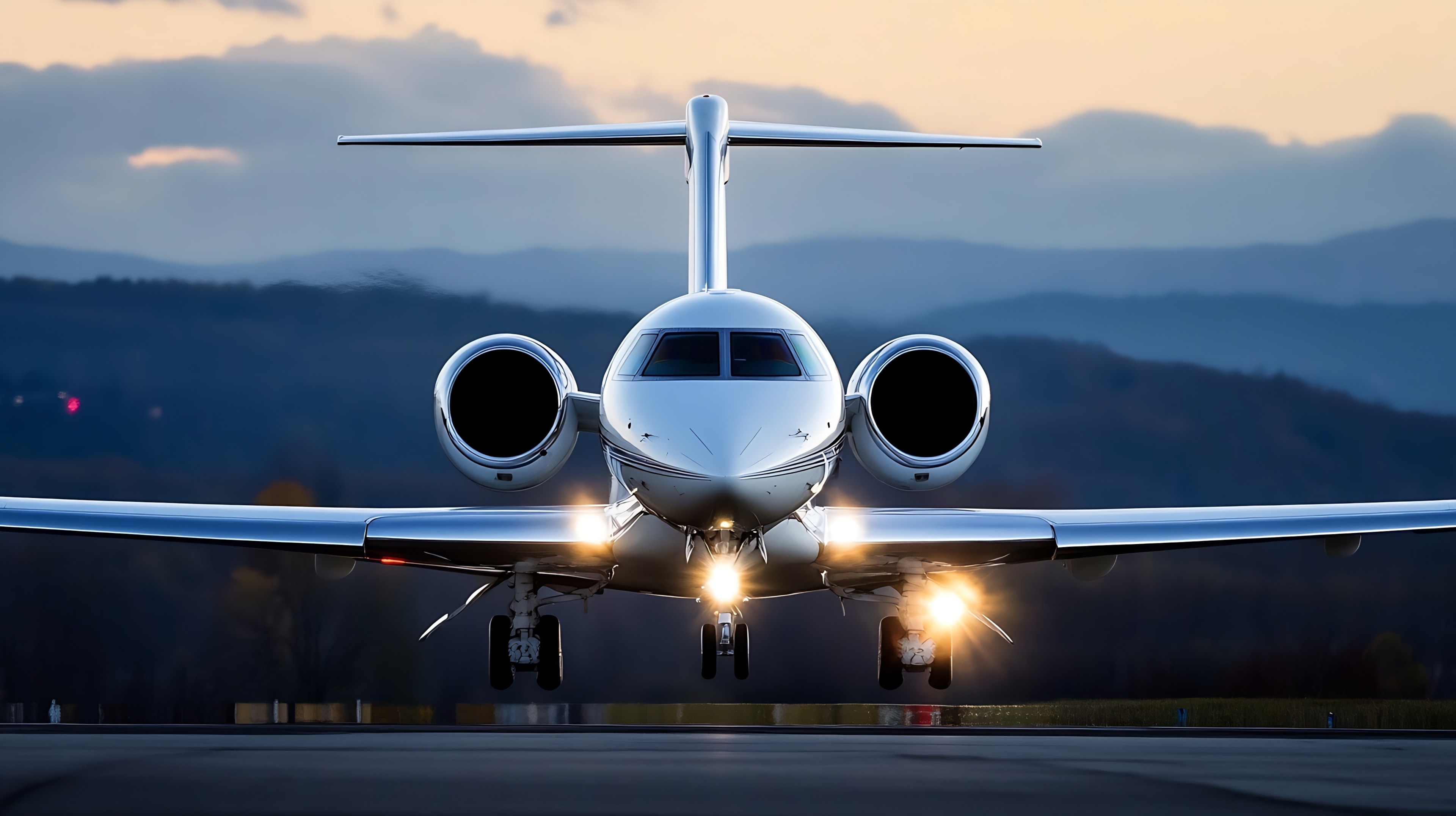 Sleek and modern private jet on a runway with headlights on ready for takeoff against a dramatic sunset backdrop