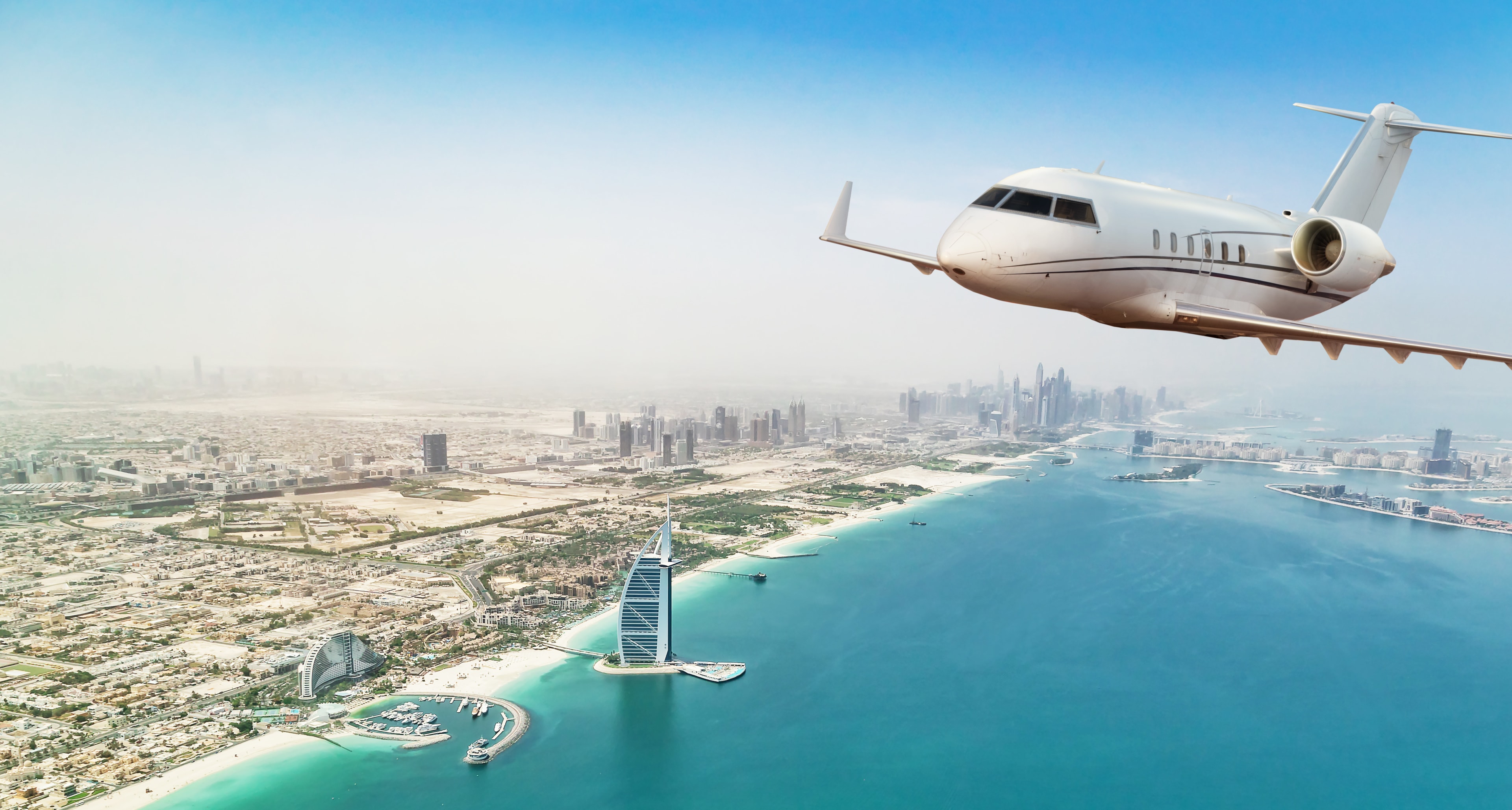 Private jet plane flying above Dubai city