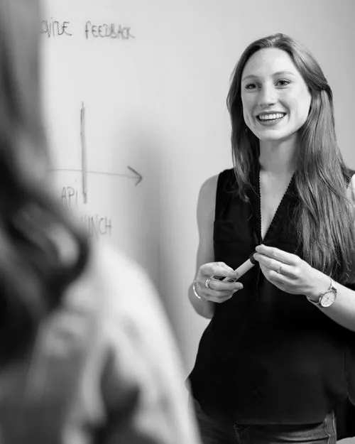 Women smiling a person next to whiteboard