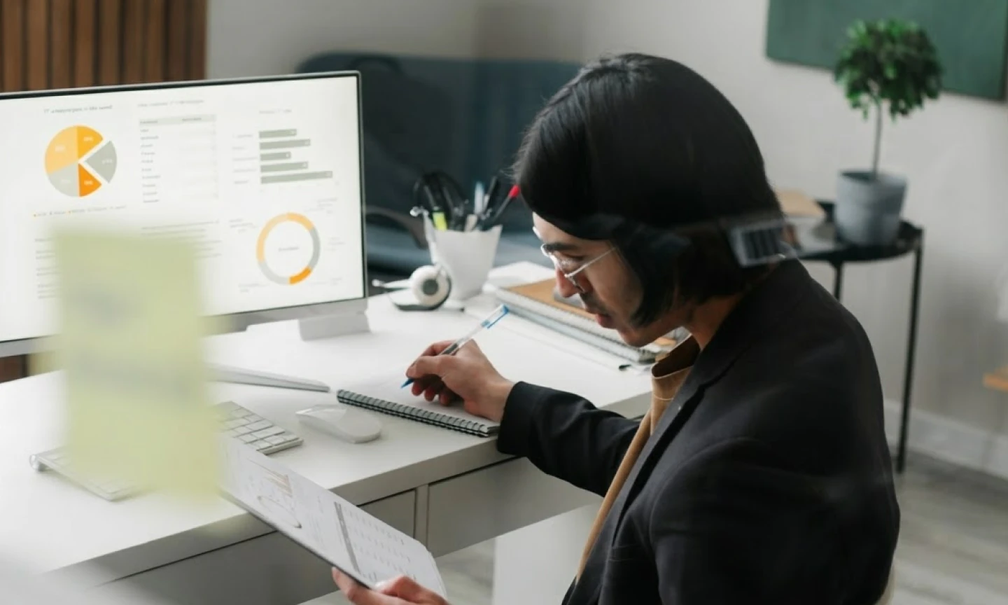This comundo blog post about CSRD has a header image showing a man working at a desk with a monitor in the background. He's holding papers in one hand and taking notes with the other. It looks complicated and boring.