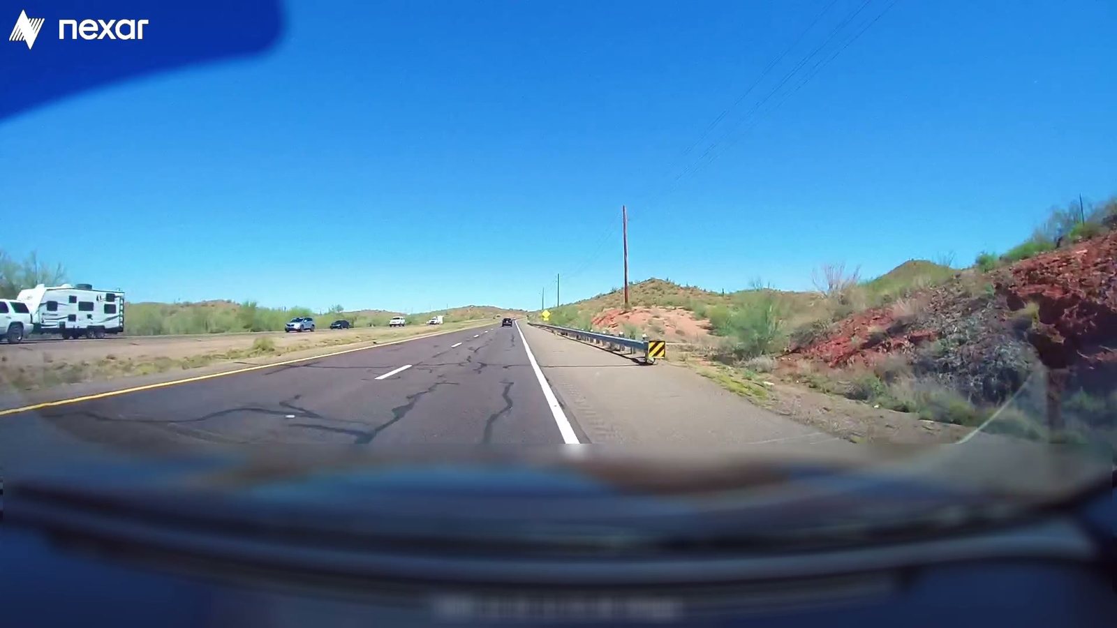 Dashcam view of an open highway through desert terrain