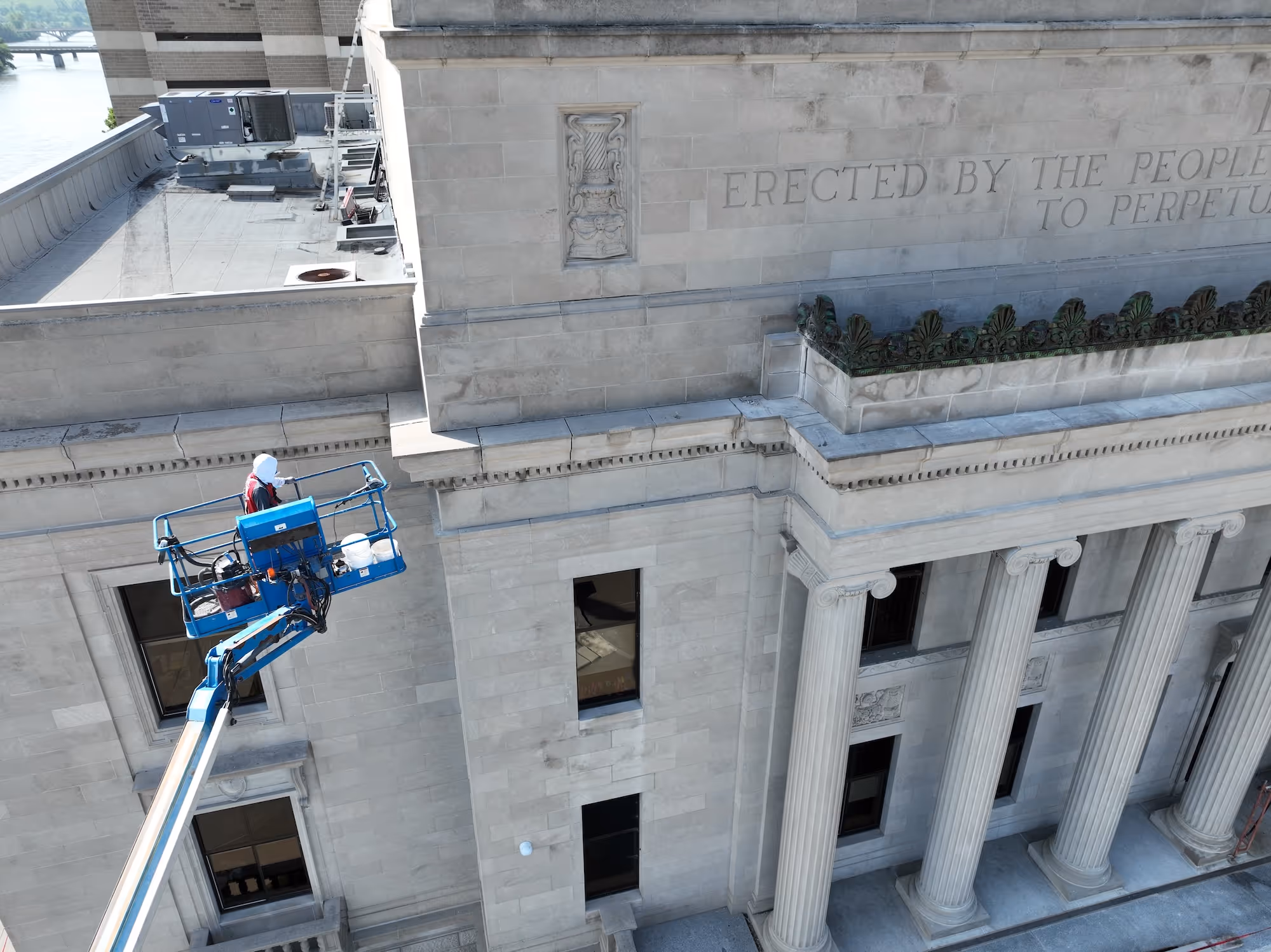 Worker on a boom lift performing exterior restoration on the Linn County Courthouse in Cedar Rapids, Iowa by TNT Tuckpointing