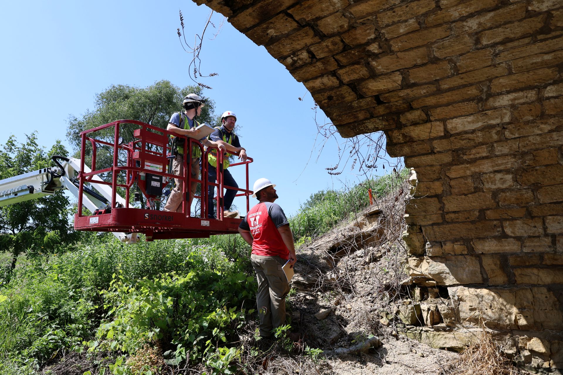 Mortar sampling and hands-on condition documentation during a masonry investigation on a historic stone arch bridge.