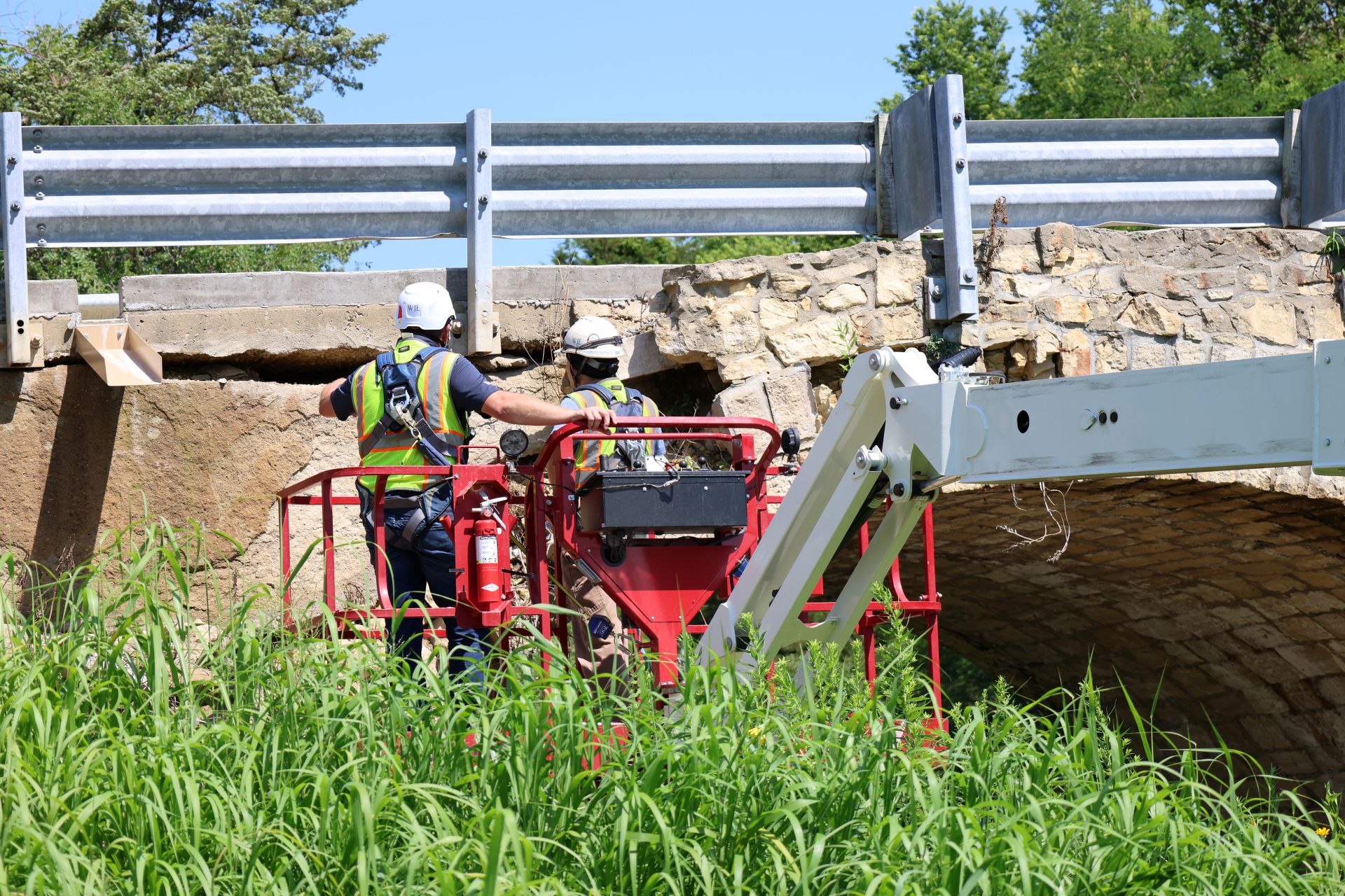 WJE inspectors documenting the failed spandrel from an aerial lift basket in full fall protection.