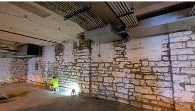TNT mason repointing a stone wall in the Crescent Lofts parking garage in Davenport, Iowa