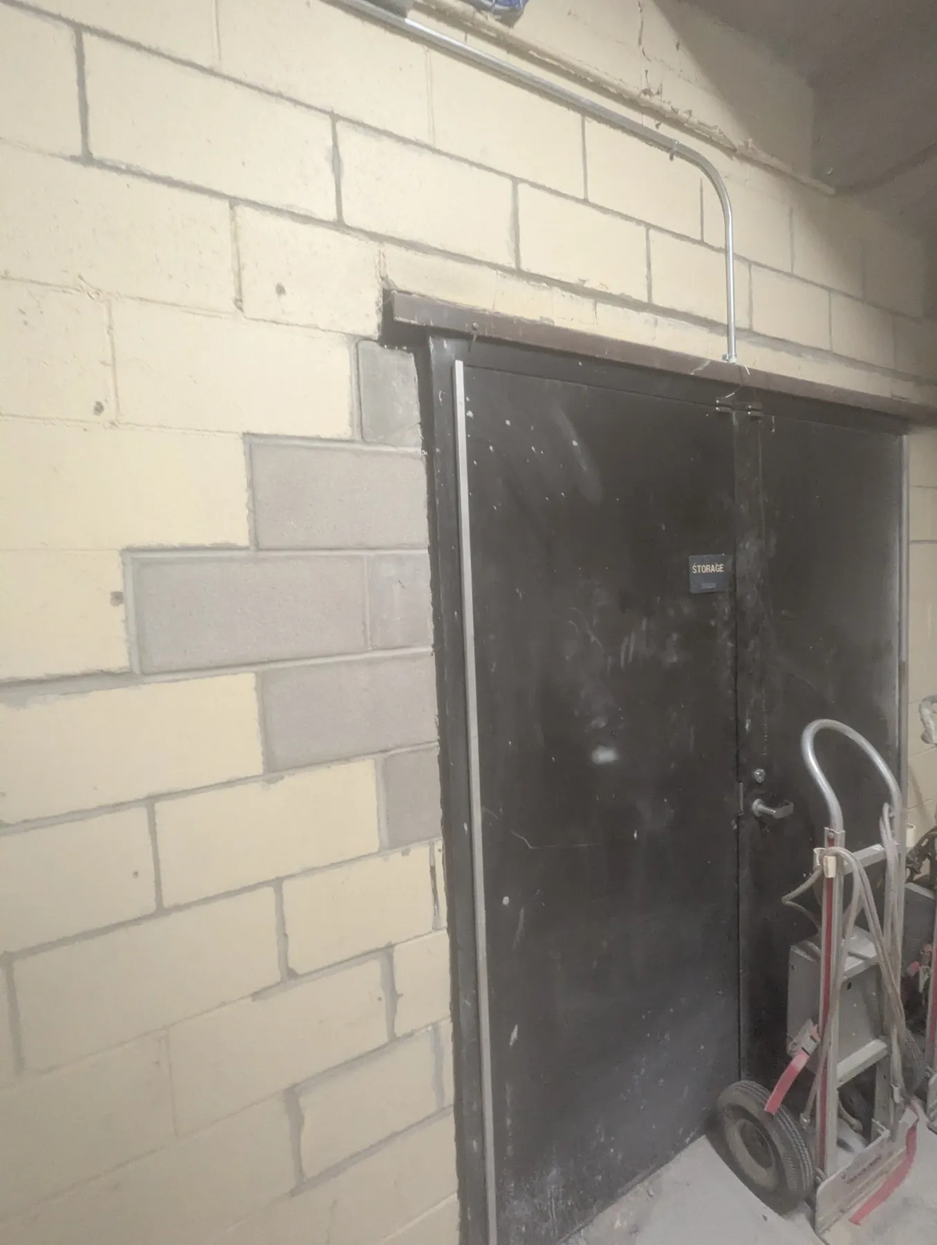 New concrete block toothed into a stepped crack beside a steel door at Brady Street Stadium in Davenport