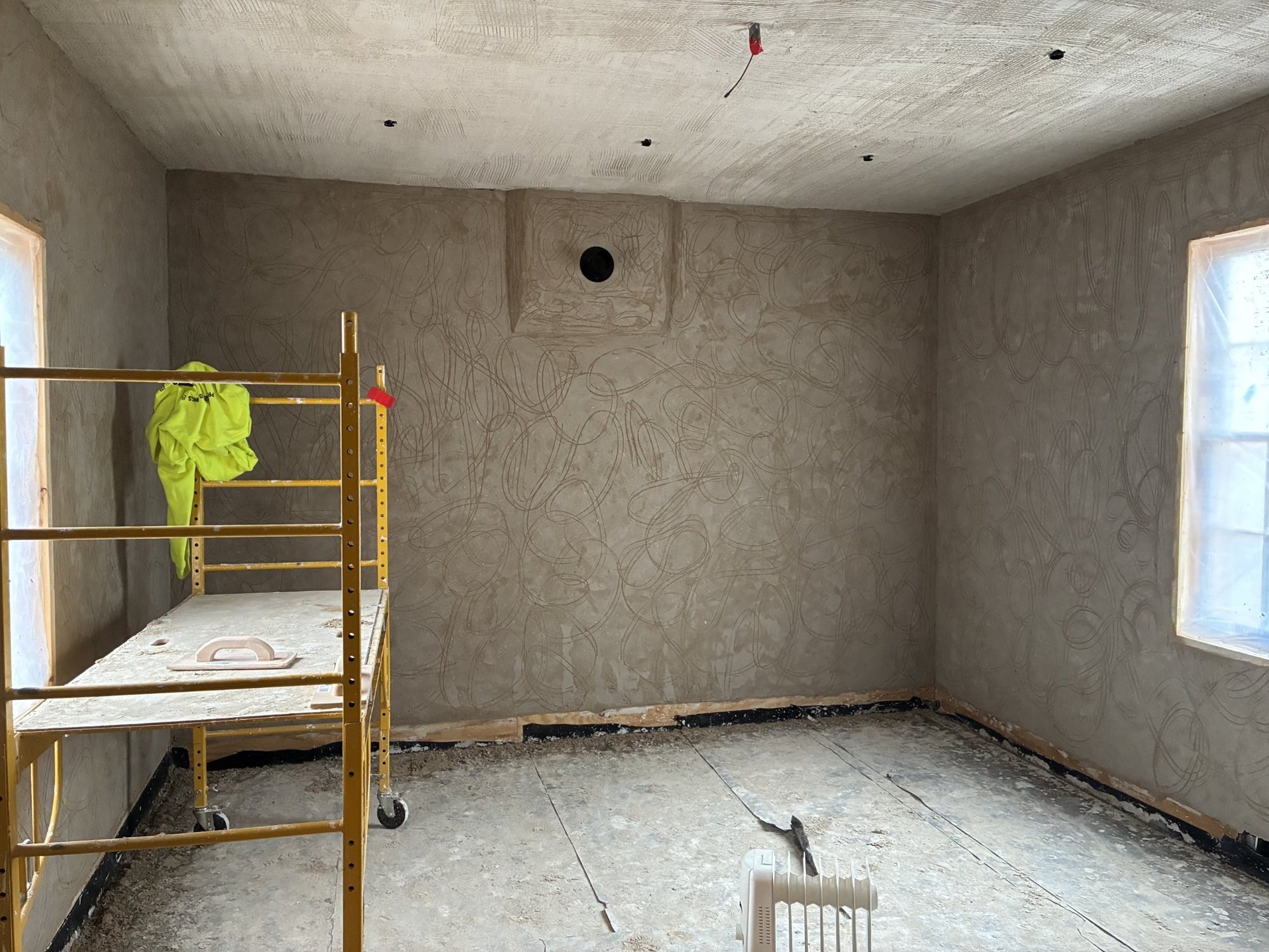 Lime plaster scratch coat, scored so the next coat can grip