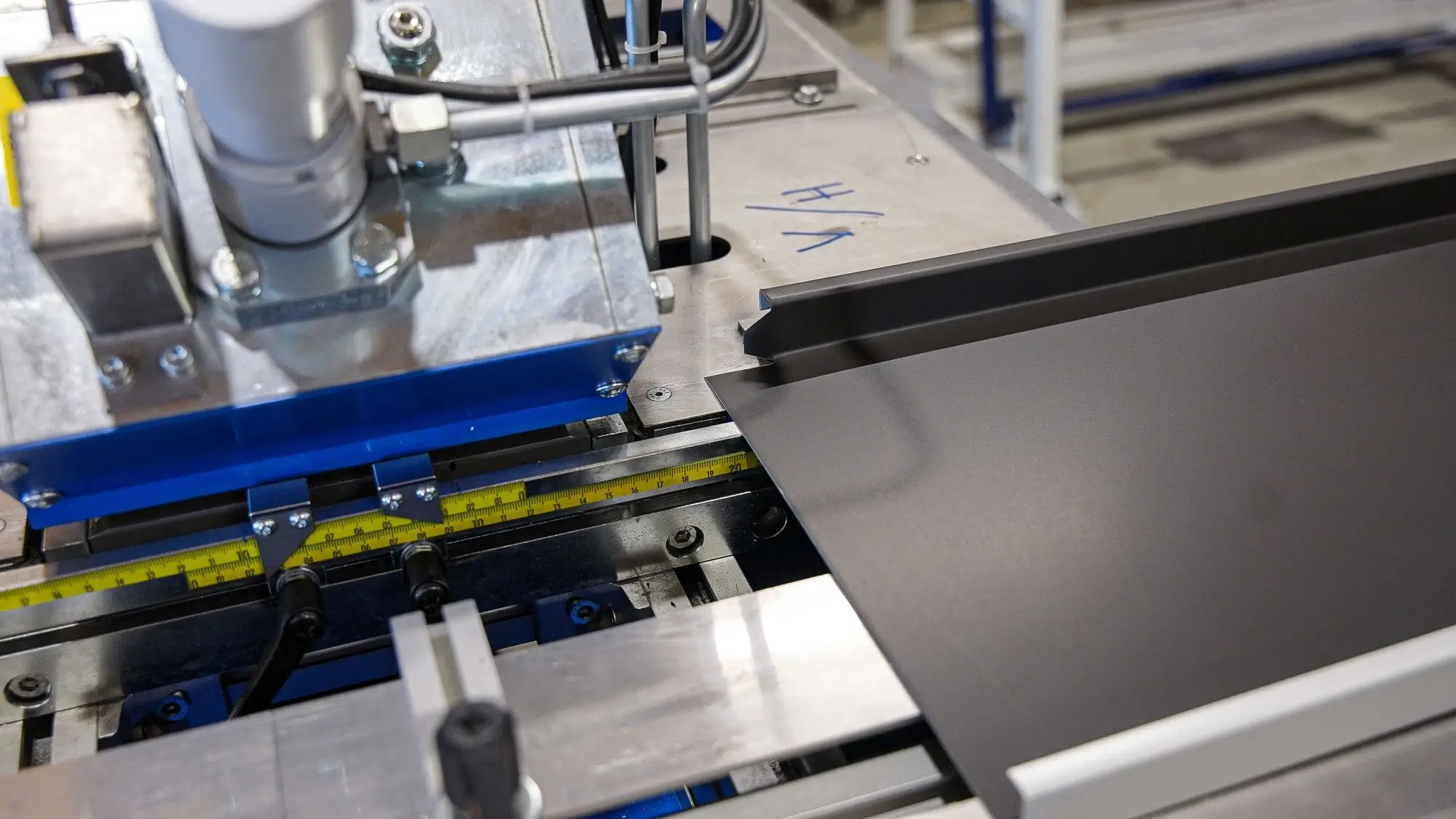 Close-up of a metal sheet being precisely cut or shaped by an industrial machine.