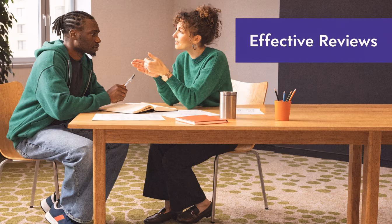 A manager having a supportive, professional discussion with an employee during a performance review meeting.