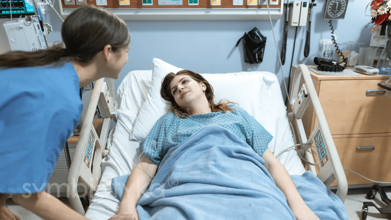 A woman laying in a hospital bed next to another woman.