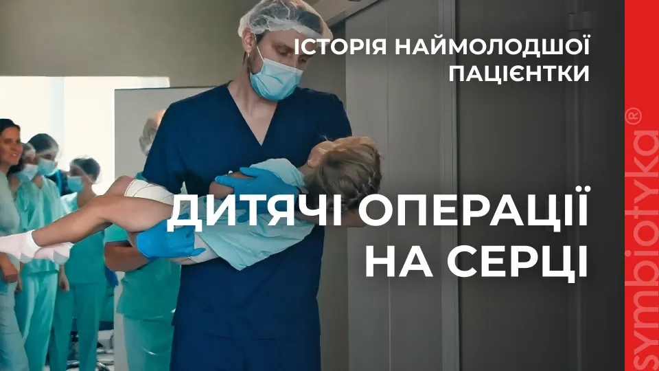 A woman in scrubs is holding a child.